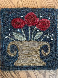 a close up of a rug with flowers in a vase