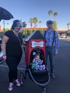 a man and woman standing next to a baby in a stroller