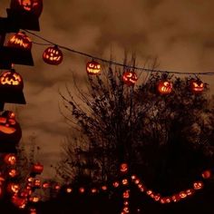 many pumpkins are lit up in the night sky and hanging from wires with halloween lights on them