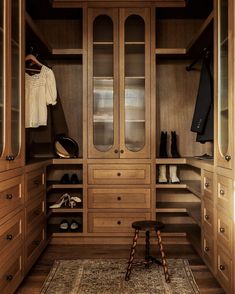 a walk in closet filled with lots of wooden furniture