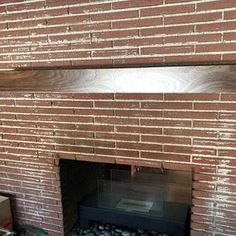 a fire place with rocks in it and a brick wall above the fireplace that is being built