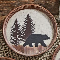 three brown and black plates with bear designs on them