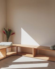 a corner table with two vases on it and a plant in the corner next to it