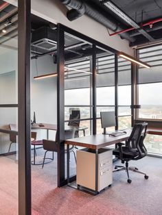 an office with glass walls and lots of desks