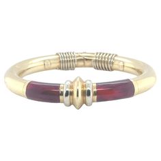 This SOHO Italian Red Enamel Hinged Bangle Bracelet is a modern and elegant accessory, crafted from luxurious 18 Karat Yellow Gold. The bracelet, measuring 9mm in width and 2.25 inches in diameter, features a bold red enamel inlay that creates a striking contrast against the warm yellow gold. Handcrafted in Italy, the sleek, contemporary design is both stylish and versatile. The hinged closure ensures ease of wear and a secure fit, making this bangle a perfect statement piece to add a pop of color and sophistication to any ensemble. Weight: 33.2 grams. Modern Bangle, Modern Bracelets, Enamel Bangle, Diamond Bangles Bracelet, Warm Yellow, Diamond Bangle, Elegant Accessories, Hinged Bangle, Gold Enamel