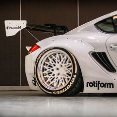 a white sports car parked in front of a building with the word rotform on it's side