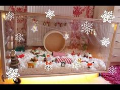 a display case filled with lots of snow and christmas decorations on top of a table