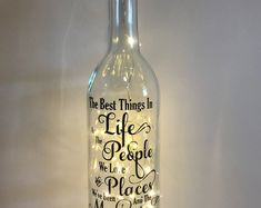 a wine bottle with lights in it that says the best things in life are people