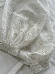 These are a pair of beautiful French antique sleeves made in fine baby voile and have an abundance of hand embroidered whitework. The embroidery depicts trailing vines and grapes and the quality of the embroidery is exquisite. They have a band of heavier cotton at the top which has hand embroidered "22" and one sleeve has the letter T. Length : 16 3/4" Cuff depth : 1" Cuff circumference: 7" Baby voile is a fragile fabric and there are a few imperfections but overall they are in good condition fo Vintage White Blouse With Intricate Embroidery, White Embroidered Blouse With Bishop Sleeves, White Puff Sleeve Blouse With Floral Embroidery, White Broderie Anglaise Wedding Blouse, White Broderie Anglaise Blouse For Wedding, White Embroidered Cottagecore Blouse, Traditional White Blouse With Lace Trim, Whitework Embroidery, The Letter T