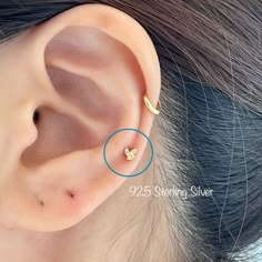 a woman's ear is shown with two small gold stars on the top of it