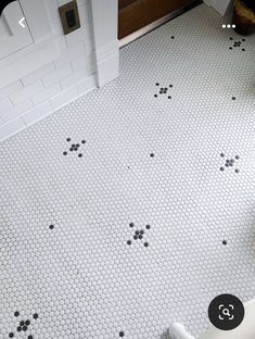 the bathroom floor is covered in black and white hexagonal tiles with paw prints