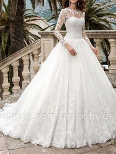 a woman in a wedding dress standing on a balcony