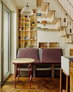 a room that has some chairs and a table in it with shelves on the wall