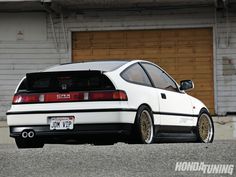 a white car parked in front of a garage