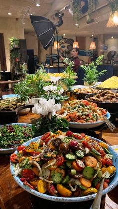 a table filled with lots of different types of food on top of wooden tables covered in plates