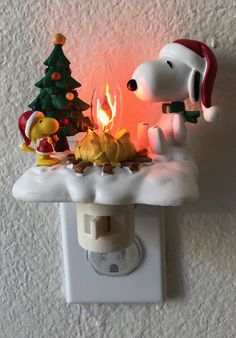 a light that is on the side of a wall with a snoopy christmas decoration