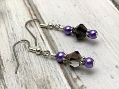 A great pair of beaded dangle earrings for any occasion. Earrings are made using surgical steel ear wires. Earrings come with rubber ear backs that slide on to keep earrings from falling out of ears. Color: silver, black crystal, violet glass pearl Earrings length: 1 5/8 INCHES YOU MAY ALSO LIKE:https://www.jillsbeadedknitbits.com/search?q=black+earringsSHIPPING NOTE: ****This item is handmade with care for you, it needs 1-5 BUSINESS DAYS FOR PRODUCTION AND SHIPPING depending on size and volume Purple Beaded Dangle Earrings With Black Beads, Elegant Purple Crystal Earrings With Dangling Beads, Purple Adjustable Drop Crystal Earrings, Purple Dangle Earrings With Black Beads, Purple Amethyst Earrings With Dangling Beads, Crystal Purple, Electronic Gifts, Slide On, Beaded Dangle Earrings