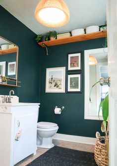 a bathroom with green walls and pictures on the wall