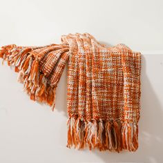 an orange and white blanket hanging on the wall