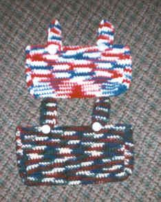 two bags made out of knitted material sitting on top of a cloth covered surface