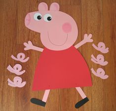 a paper cut out of peppo the pig on a wooden floor