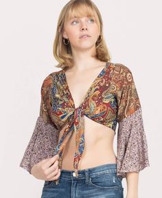 This Paisley Patchwork Hippie Top will keep your hippie spirit vibin'! Groove on to the dance floor with its 3/4 flare sleeves, front tie, and v-neckline. Features a beautiful collection of paisley and floral designs. Due to its patchwork, each one is unique. Ethically made in India. 70% Polyester, 30% Silk. Maroon. Spring Bohemian Cropped Blouse, Summer Cropped Bohemian Peasant Top, Multicolor Boho Print Peasant Top In Hippie Style, Hippie Floral Print Peasant Top For Festivals, Hippie Boho Print Blouse For Spring, Hippie Style Boho Print Blouse For Spring, Hippie Cropped Tops For Spring, Spring Bohemian Tops With Tie Sleeves, Bohemian Tops With Tie Sleeves For Spring