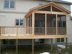 a house with a covered porch in front of it and snow on the ground outside