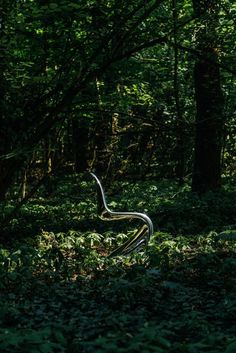 a snake statue in the middle of a forest