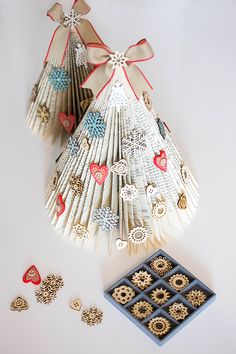 an origami christmas tree next to other ornaments and decorations on a white surface