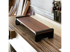 a wooden shelf sitting on top of a counter next to a pile of book cases