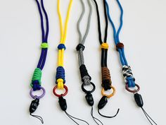 four different colored lanyards with black handles on white background, one has an umbrella