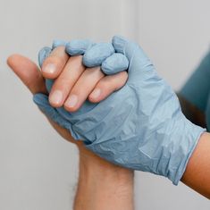 a person wearing blue gloves and holding something in their hand with one hand on the other