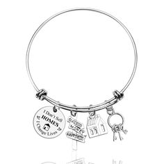 a silver bracelet with charms on it and a house key hanging from the end of it