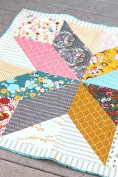 a close up of a patchwork quilt on a wooden floor with the center piece missing