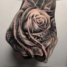 a man's hand with a rose and money tattoo on it