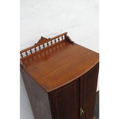 an old wooden cabinet sitting next to a white wall