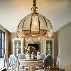 a dining room table with chairs and a chandelier hanging from it's ceiling