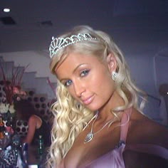 a woman wearing a tiara standing next to a table