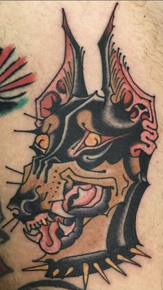 a close up of a tattoo on the back of a man's stomach with an animal head