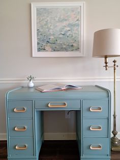 a blue desk with two drawers and a lamp