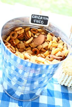 a bucket filled with cheetos sitting on top of a blue checkered table cloth