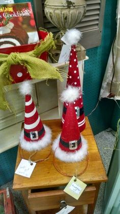 two red and white christmas hats sitting on top of a wooden table