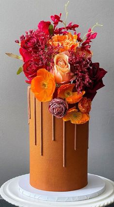 a cake decorated with flowers and chocolate drips