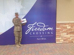 a man in uniform standing next to a sign