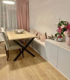 a dining room table with chairs and flowers on it