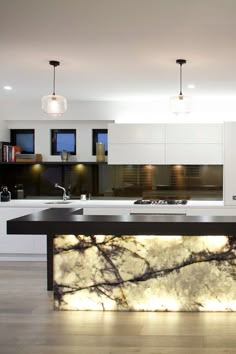 a modern kitchen with marble counter tops and an island in front of the stove top