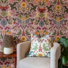 a living room with a chair, lamp and wallpaper on the walls in different colors