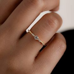 a woman's hand with a diamond ring on top of her finger and the other hand holding it