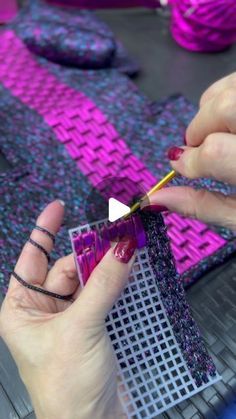 the woman is working on her craft project with purple and black material, including crochet