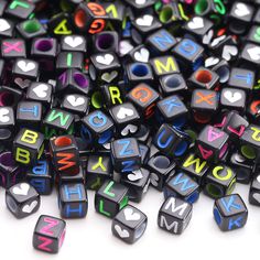 the letters are made up of small black cubes with multicolored letters on them